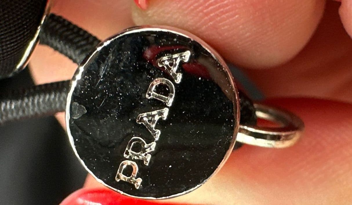 Бирка Prada у шеи